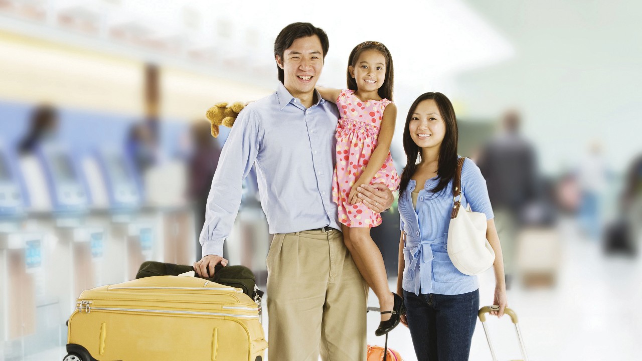 Gia đình cùng hành lý tại sân bay; hình ảnh được sử dụng cho trang Bảo Hiểm Du Lịch HSBC Việt Nam