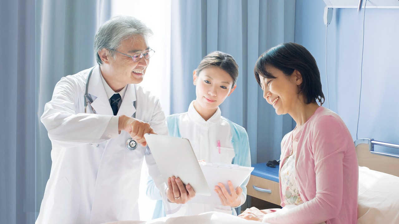 Bệnh nhân nữ gặp bác sĩ khám bệnh tại bệnh viện; hình ảnh được sử dụng cho trang Bảo Hiểm Sức Khỏe Việt Nam 